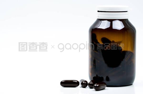 黑色硬胶胶囊药丸和琥珀玻璃瓶,白色背板上有空白标签